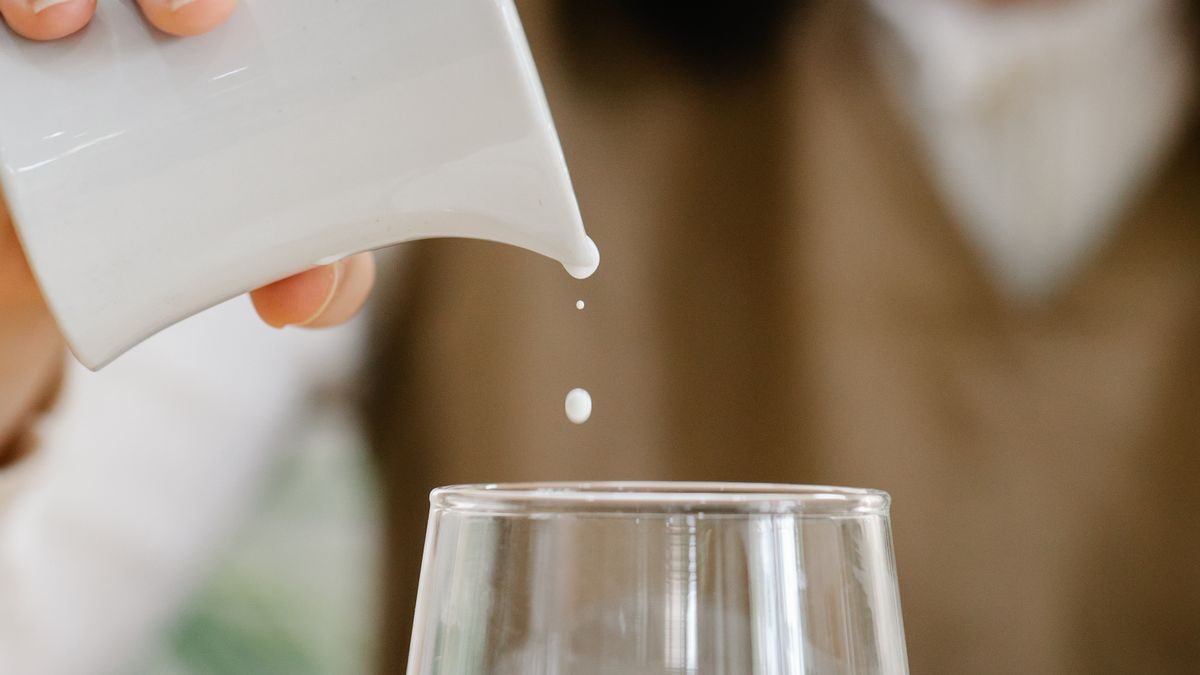 Leche sirviéndose en un vaso de vidrio